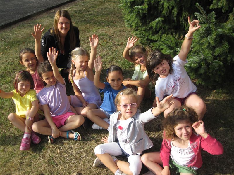 Un groupe d'enfants en stage, bras levés